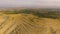 View of sandy hilly terrain of Armenia, small village in distance, Caucasus