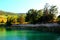 View from Santarelli lakes with emerald waters into a ridge with green trees and sun