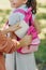 View of schoolboy packing book in backpack of smiling schoolgirl