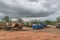 View of scrap with several vans dismantled and other vehicles, rainforest and cloudy sky as background