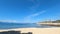 View of the sea from the beach on a sunny day with the ship industry in the background. Timelapse video of ocean waves