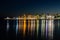 View of the sea and city lights reflection in it at night in Porto Cesareo