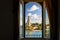 View of the sea, landscaping and Italian Sailors Monument through an arched window in Brindisi Italy