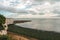 View of sea at low tide and empty beach with Chalk Cliff Arch in Margate, England