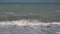 View of the sea moving with calm waves with white foam