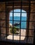 View of the sea and the ships through the bars on the window in the White Tower in Thessaloniki, Greece