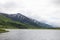 View from the sea of steep rocky mountains with lush vegetation in Alaska