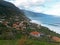 View on the sea waves, cllifs, green hills road and village in Madeira Portugal, north coast