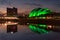 View of the SEC Armadillo lit up in green, reflected in the Clyde River