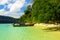 View on secluded beach in remote bay with turquoise water and thai long-tail boats, Ko Lipe, Thailand