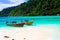 View on secluded beach in remote bay with turquoise water and thai long-tail boats, Ko Lipe, Thailand