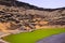 View on secluded deep green lake Lago verde in lagoon surrounded by impressive cliffs - El Golfo, Lanzarote