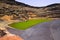 View on secluded deep green lake Lago verde in lagoon surrounded by impressive cliffs - El Golfo, Lanzarote