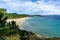 View of a secluded golden sand beach with forest behind