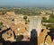 View of a section of San Gimignano on the background of Tuscan landscape, taken from Torre Grossa, casting a shadow