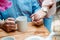 View of senior man with cup of tea holding hands with retired wife