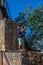 View at a senior tourist taking a photo with his phone, on interior medieval fortress village