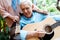 View of senior woman standing near happy retired husband playing acoustic guitar