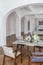 a view of a set dining table in a chic expensive bright interior of a huge living room in a historic mansion with arched arches,