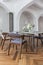 a view of a set dining table in a chic expensive bright interior of a huge living room in a historic mansion with arched arches,