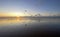 View of the setting sun shining on the Sea and reflected on the beach, clouds with sun-shining edges. Landscape