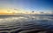 View of the setting sun shining on the Sea and reflected on the beach, clouds with sun-shining edges. Landscape