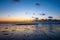 View of the setting sun shining on the Sea and reflected on the beach, clouds with sun-shining edges. Landscape