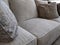 view of several pillows piled on a light colored couch in a living room