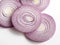 View of several round slices of a red onion