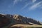 View of shadowed side jagged mountains with snow