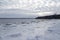 View of sheets of ice on the Cap-Rouge bay beach with altocumulus clouds in the sky