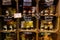 View on shelf made by wooden wine cases inside French shop with typical products. Glass jars with perfumed candles bougies prese