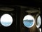 View from the ship cabin through a round porthole, on a green sea island. Sea transport concept. Transportation of people by sea