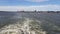 View of the shore and ocean from the stern of the ship.View of the waves following the ship in sunny weather.