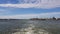 View of the shore and ocean from the stern of the ship.View of the waves following the ship in sunny weather.