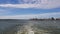 View of the shore and ocean from the stern of the ship.View of the waves following the ship in sunny weather.