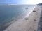 View of the shoreline from above, white waves, beach sand, clear water and rocks. Panoramic view