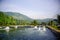 view of shrimp farm with rotating water wheel, mountains background, tambak udang.