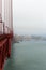 A view of the side of the Golden Gate Bridge, Marin County and the Pacific Ocean on a foggy, smog filled day