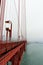 A view of the side of the Golden Gate Bridge, Marin County and the Pacific Ocean on a foggy, smog filled day in California