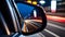 View of the side mirror from the rear of a business class car driving along the line at high speed.