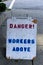 View of sign `Danger! Workers above` on sidewalk