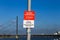 View on sign with information prohibited to rest and sit verweilverbotszone, blurred bridge and river rhine background focus on