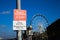 View on sign with information prohibited to rest and sit verweilverbotszone, blurred ferris wheel background