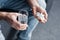 View of sitting man holding handful of pills and glass of water