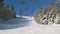 View of skiers on ski lift with snow covered mountains chairlift above ski slope