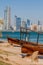 View of the skyline of Abu Dhabi from the Marina Breakwater beach with wooden boats, United Arab Emirat