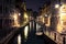 View into a small canal in Venice at night