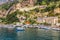 View of small haven of Amalfi village with tiny beach and colorful houses located on rock. Amalfi coast, Salerno, Campania, Italy
