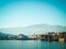 View of small italic town from embankment. Landscape, mountains and lake.